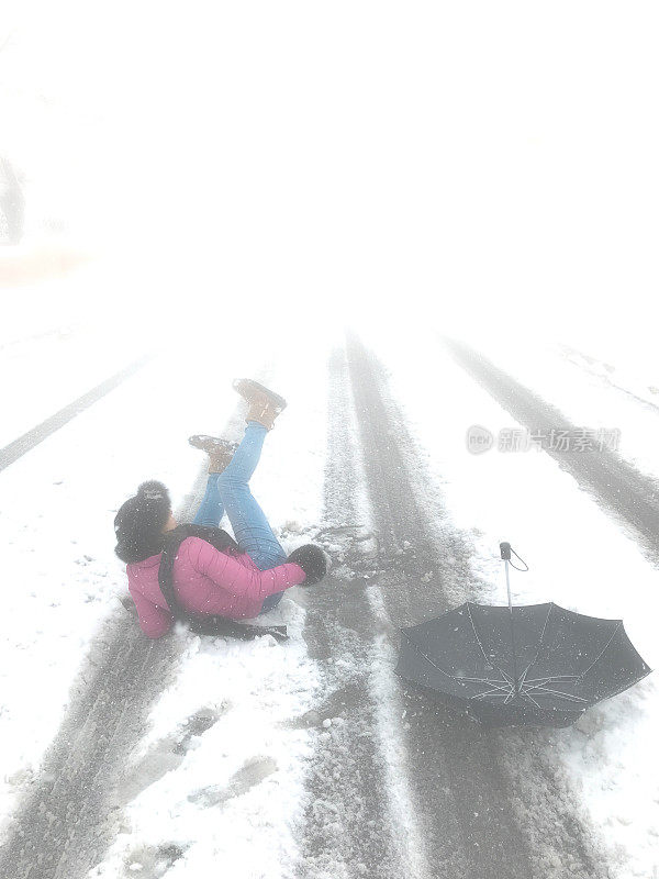 躺在路中间的女人，滑倒在新雪/冰上